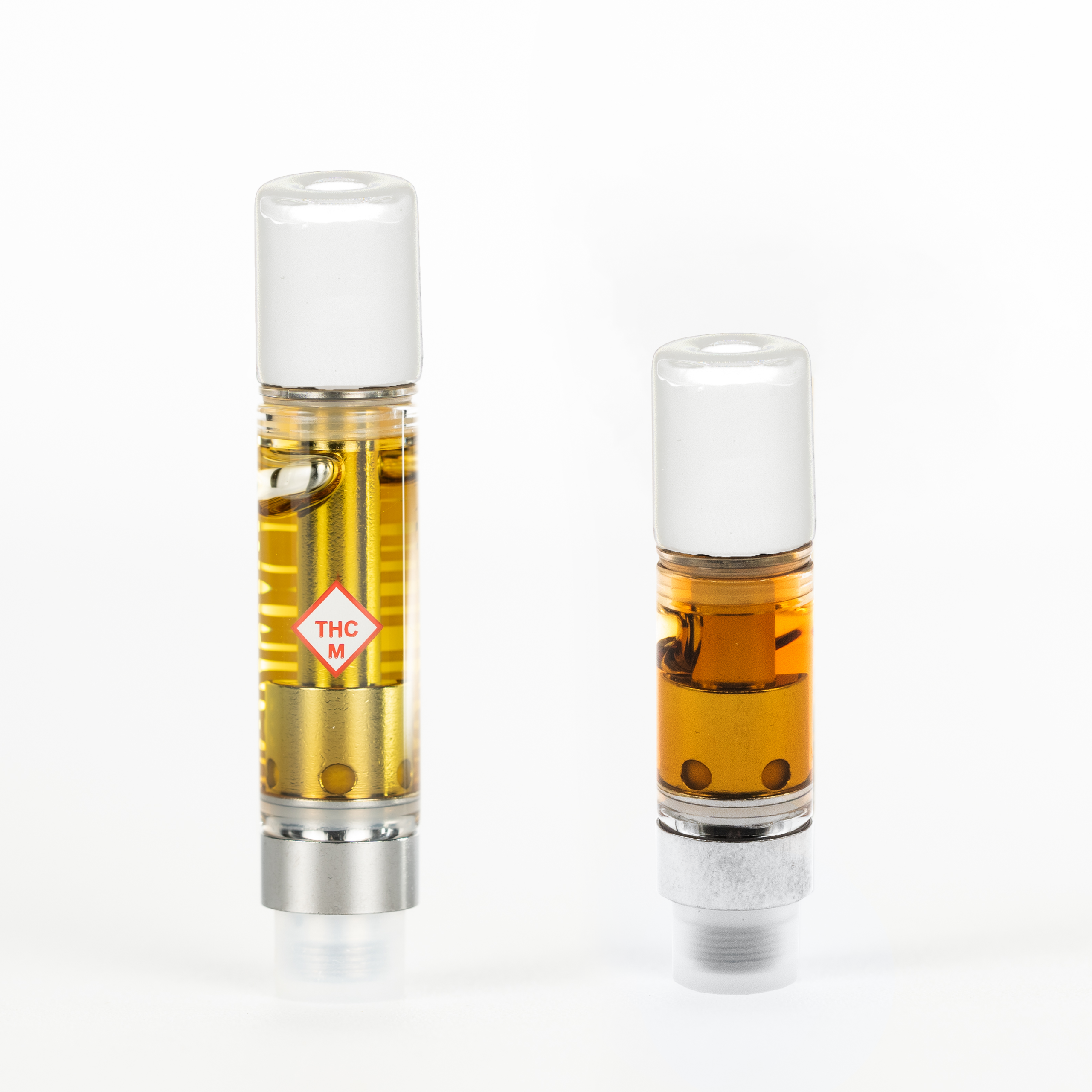 Two cannabis distillate vape cartridges standing side by side