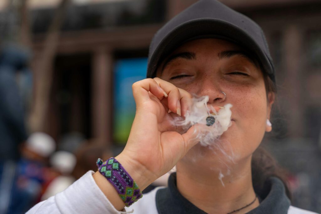 close up of a woman smoking a blunt and smiling